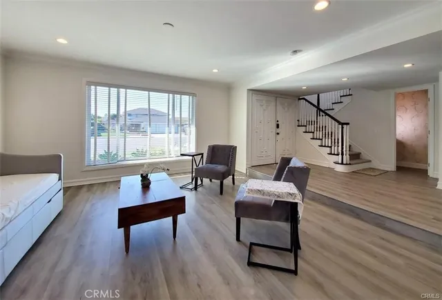 a living room with furniture and a wooden floor