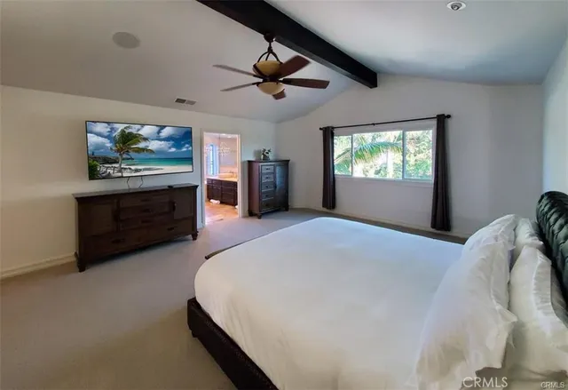 a spacious bedroom with a bed and a chandelier