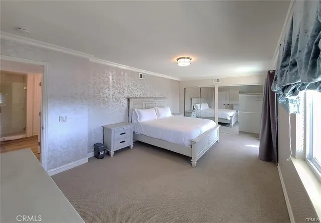 a spacious bedroom with a bed and a gate