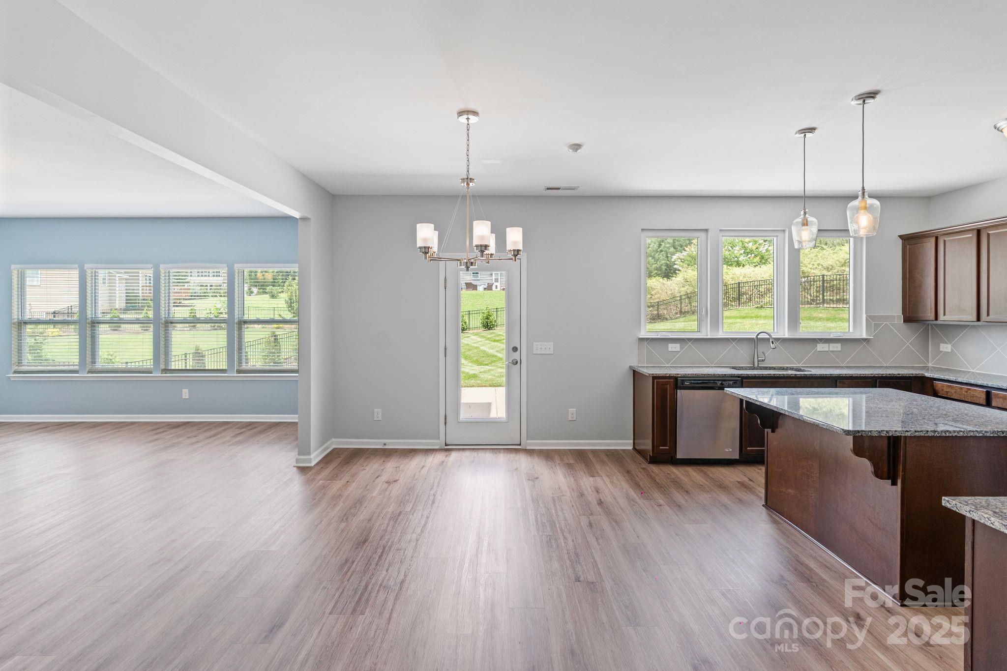 7129 Dove Field Lane Fort Mill, SC 29707 - Photo 17 of 27 a kitchen with stainless steel appliances granite countertop wooden floors and sink
