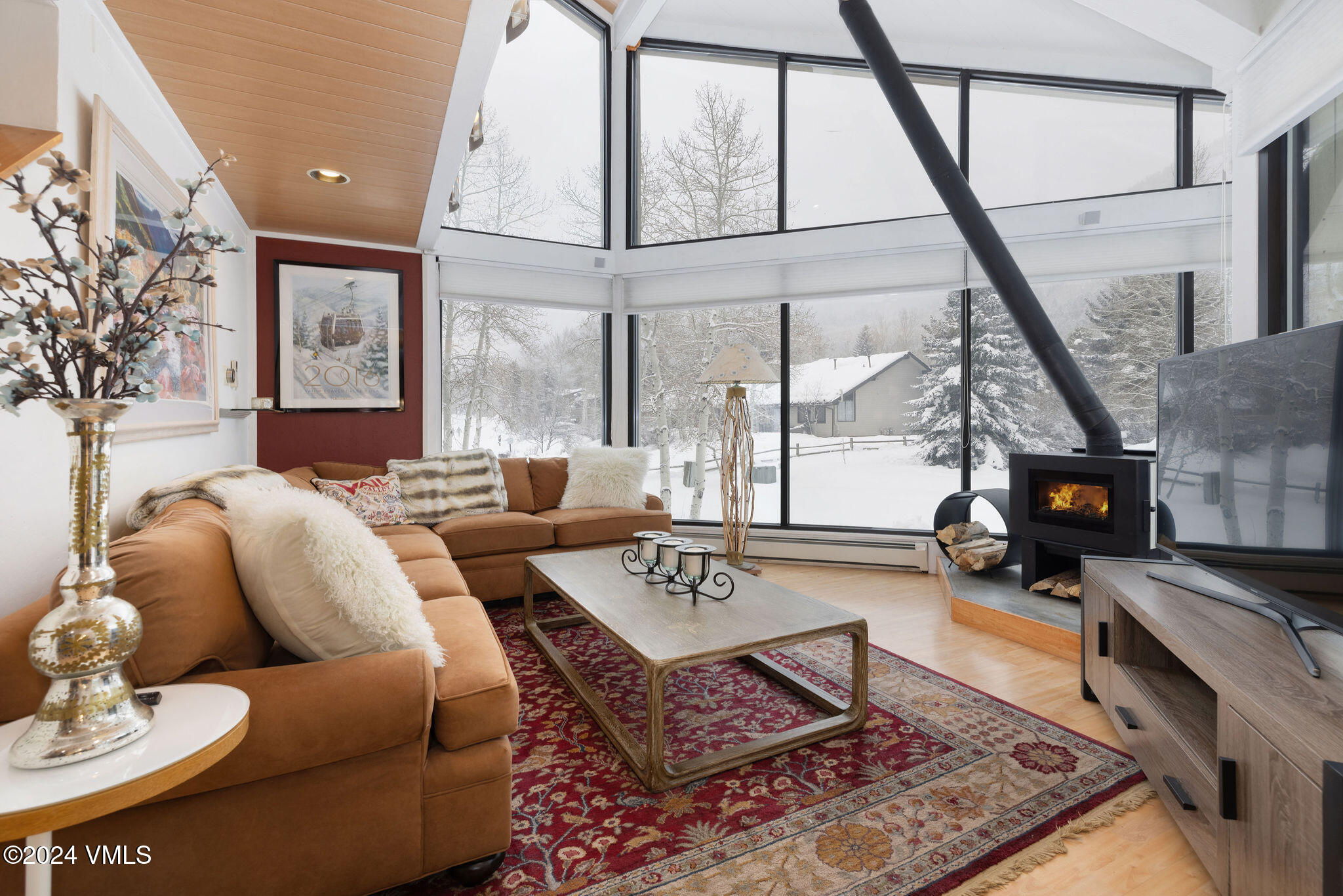 a living room with furniture a flat screen tv and a floor to ceiling window