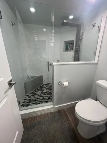 a bathroom with a toilet and a shower