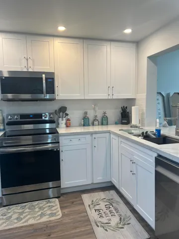 a kitchen with stainless steel appliances granite countertop a stove a sink and a microwave