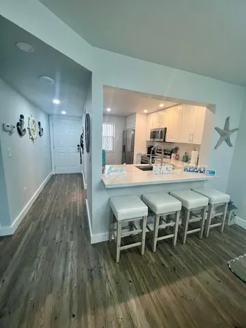 a dining room with furniture wooden floor a rug and a chandelier