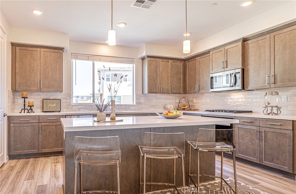 27555 Sanctuary Court Stevenson Ranch, CA 91381 - Photo 8 of 22 a kitchen with stainless steel appliances granite countertop a sink window and cabinets
