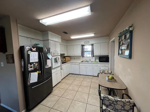 a kitchen with a sink a refrigerator and cabinets