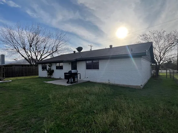 a view of a house with a big yard and large trees