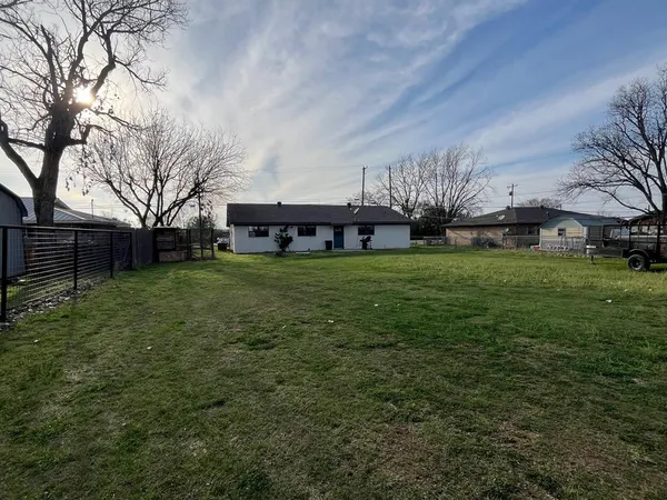 a view of a backyard with barn plants and large trees
