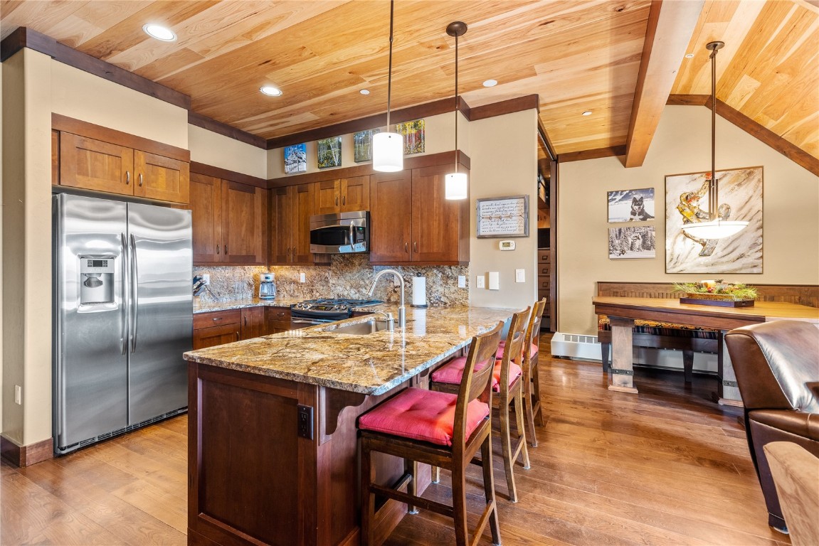 600 Columbine Road, Unit 5407 Breckenridge, CO 80424 - Photo 7 of 29 a kitchen with stainless steel appliances kitchen island granite countertop a table chairs in it and wooden floors