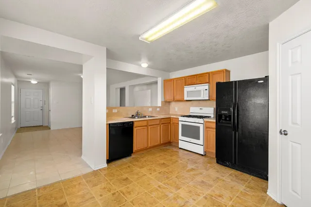 a large kitchen with a stove a refrigerator and a sink