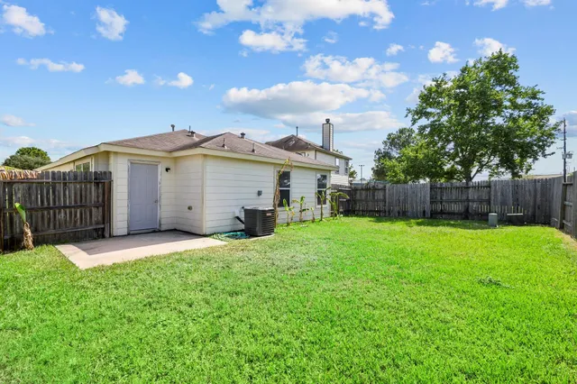 a view of a house with a yard and wooden fence