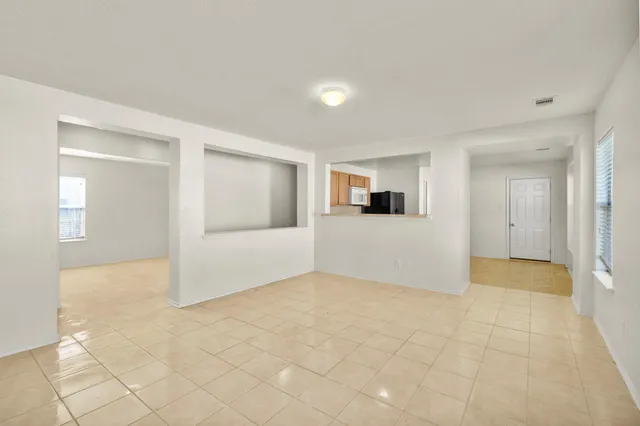 a view of a big room with wooden floor and windows