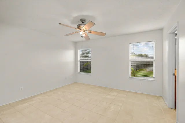 an empty room with a window and a fan