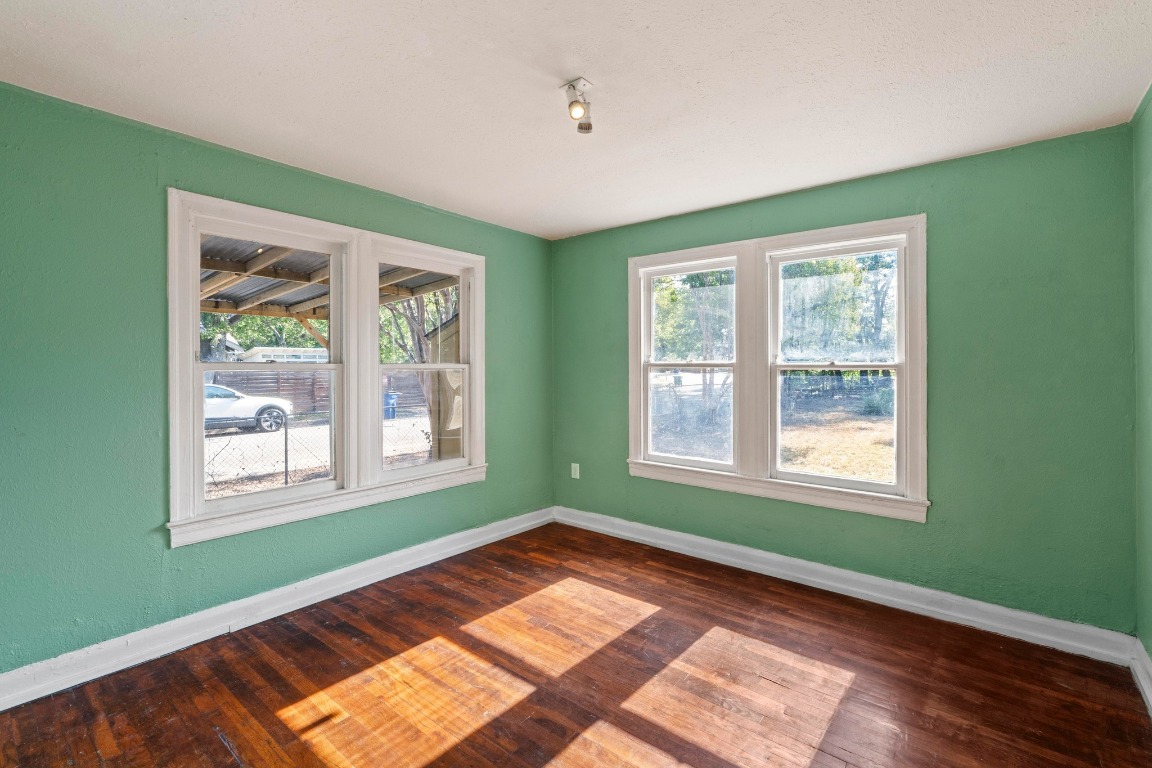 1147 Gunter Street Austin, TX 78721 - Photo 10 of 25 a view of an empty room with wooden floor and a window