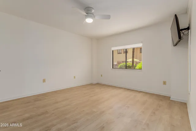 an empty room with windows and fan