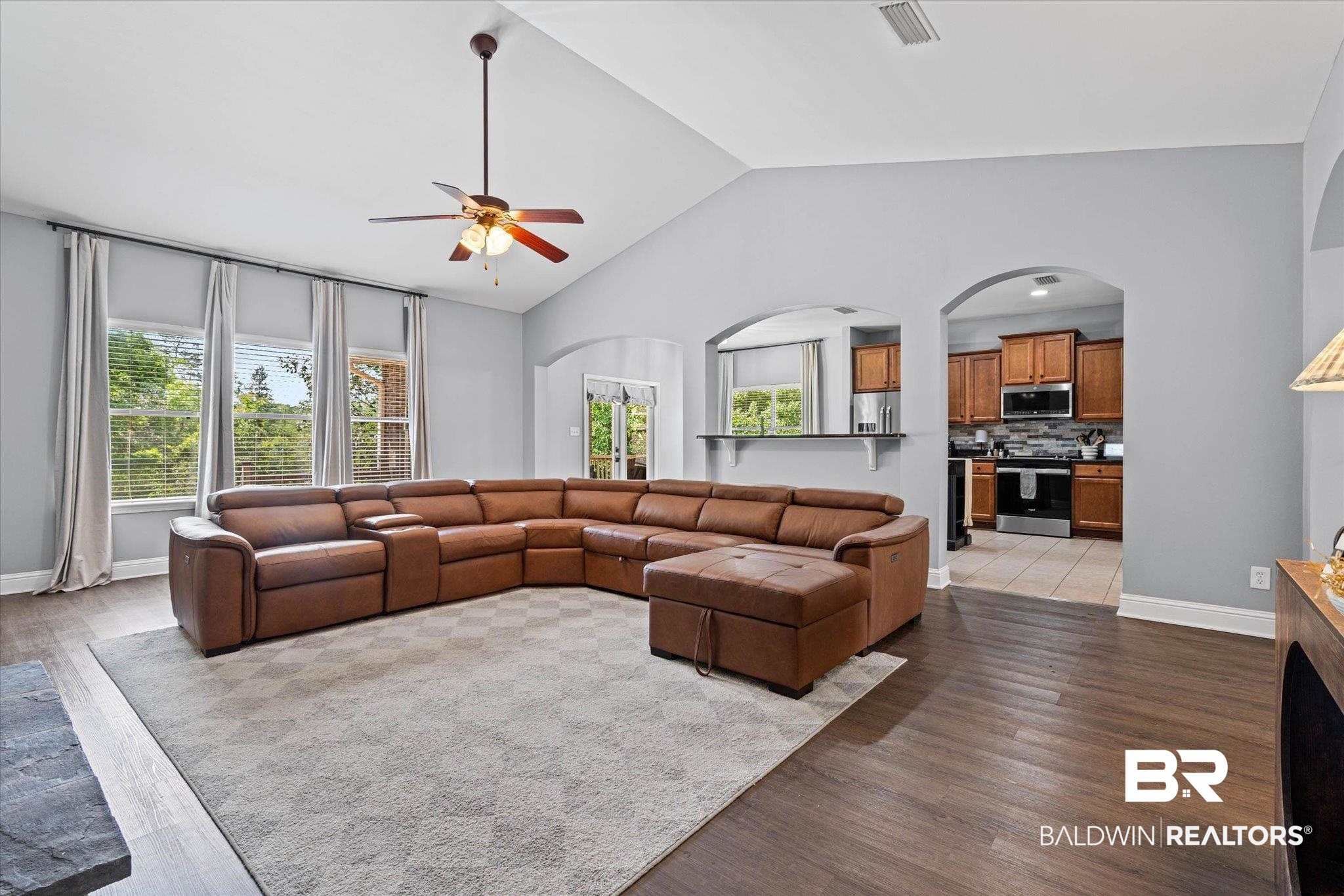 3739 Whitestone Drive Semmes, AL 36575 - Photo 5 of 25 Open-concept living area featuring vaulted ceilings, wood-finish flooring, and multiple windows