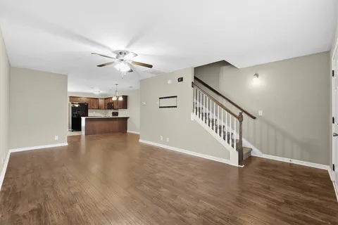 a view of a livingroom with a ceiling fan and hardwood floor