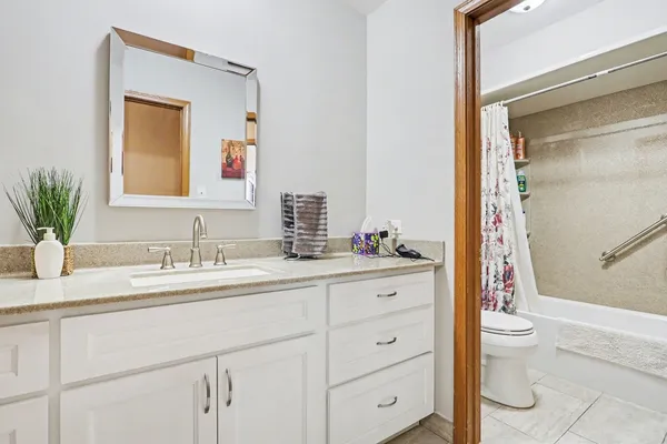 a bathroom with a granite countertop sink mirror and toilet