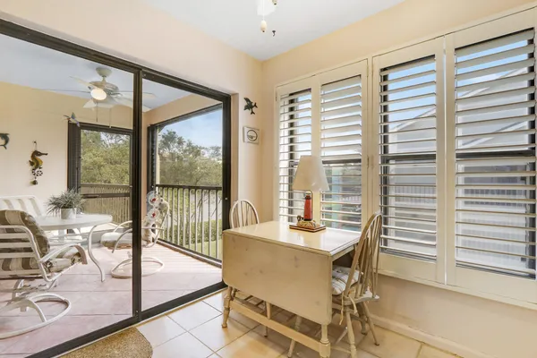 a dining room with furniture and large windows