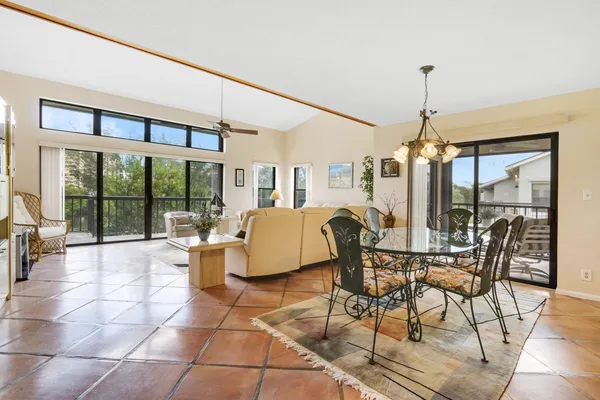 a dining room with furniture a chandelier and glass windows