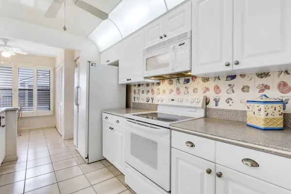 a kitchen with white cabinets and sink