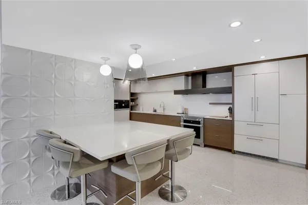 a view of a kitchen with kitchen island granite countertop lots of counter top space and stainless steel appliances