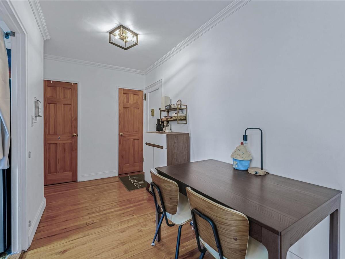 102-12 65th Avenue, Unit D22 Queens, NY 11375 - Photo 5 of 12 a view of a dining room with furniture and wooden floor