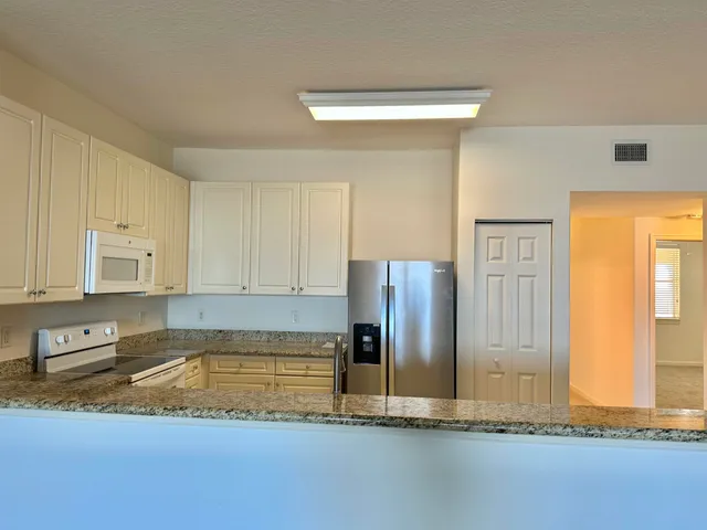 a view of an empty room with kitchen