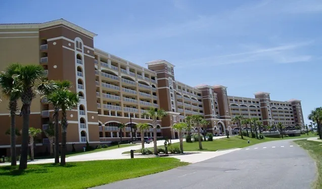 a view of a tall building next to a yard
