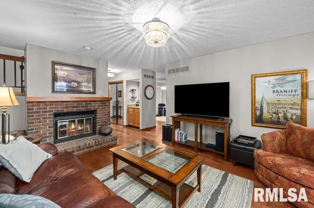 a living room with furniture a flat screen tv and a fireplace