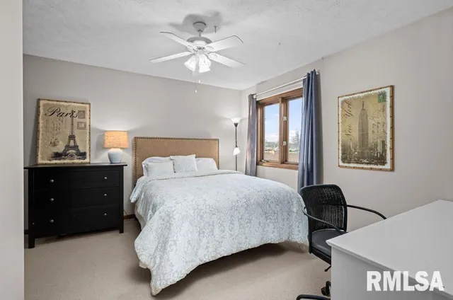 a bedroom with a bed dresser and a flat tv screen