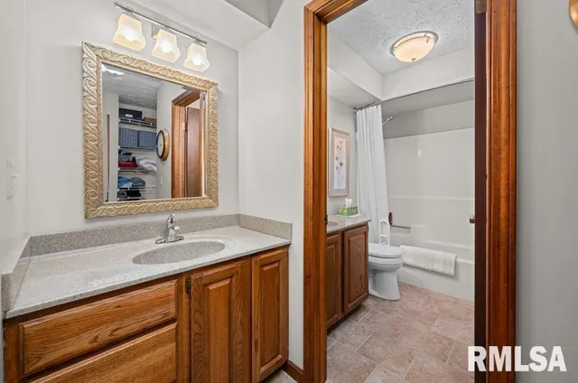 a bathroom with a granite countertop sink toilet and shower