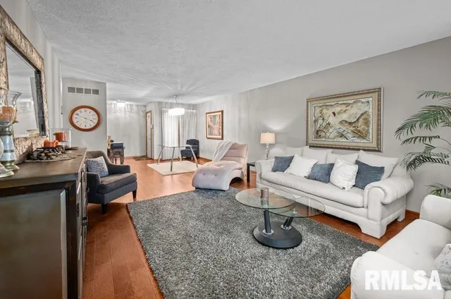 a living room with furniture a clock and white walls