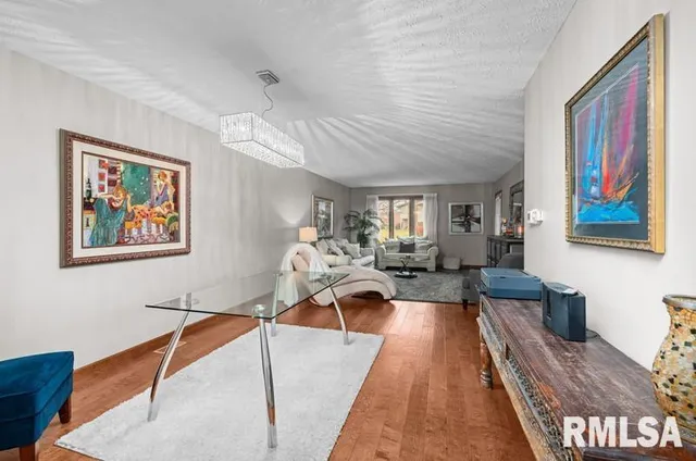 a view of a livingroom with furniture a bedroom and wooden floor