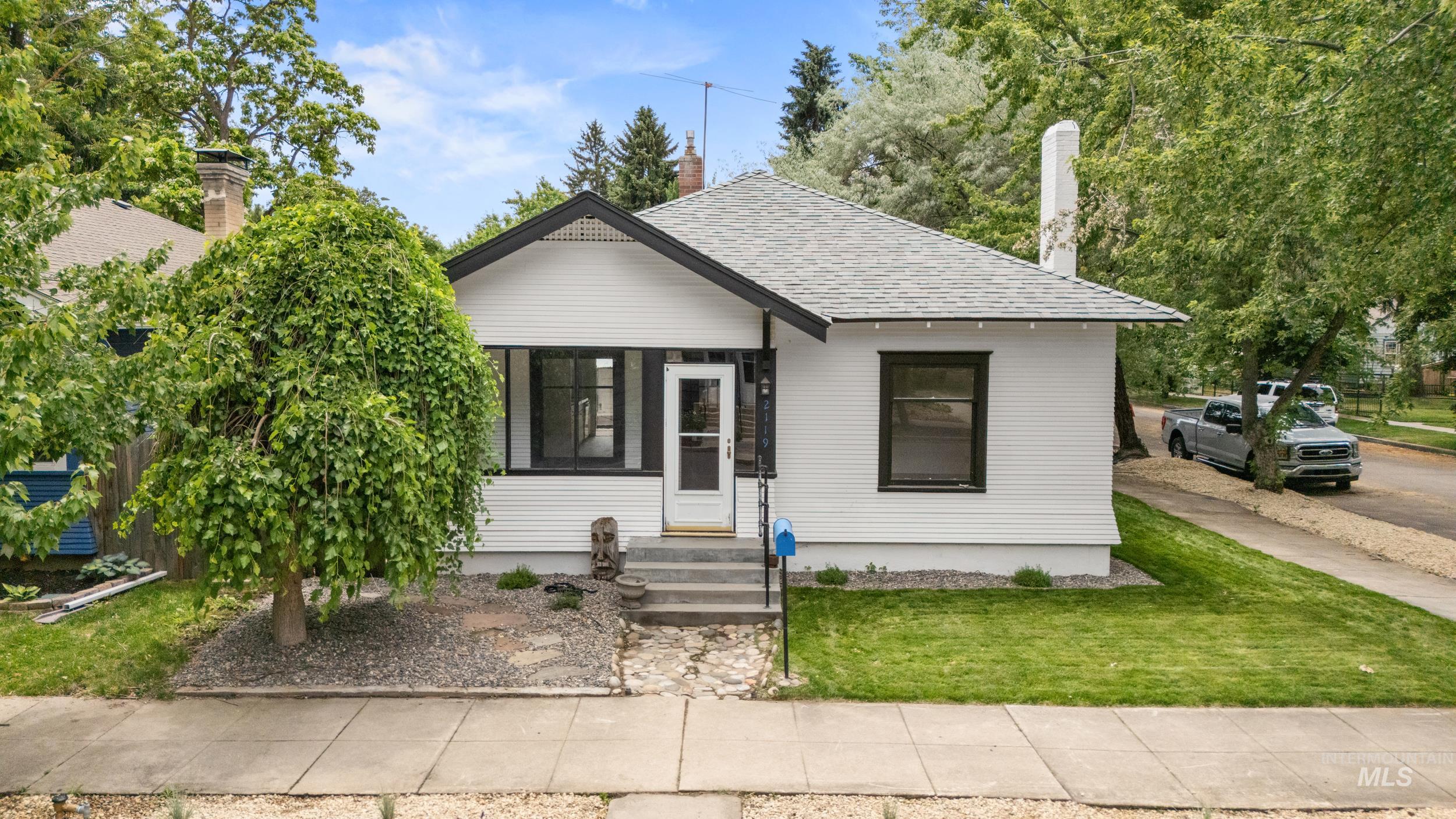 White siding exterior with black trim accents and a peaked gable roofline