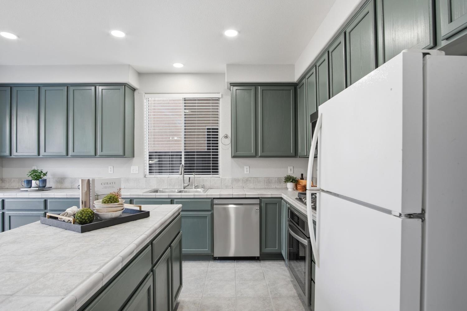 2403 Clemente Lane Tracy, CA 95377 - Photo 8 of 43 a kitchen with a sink a stove a refrigerator and cabinets