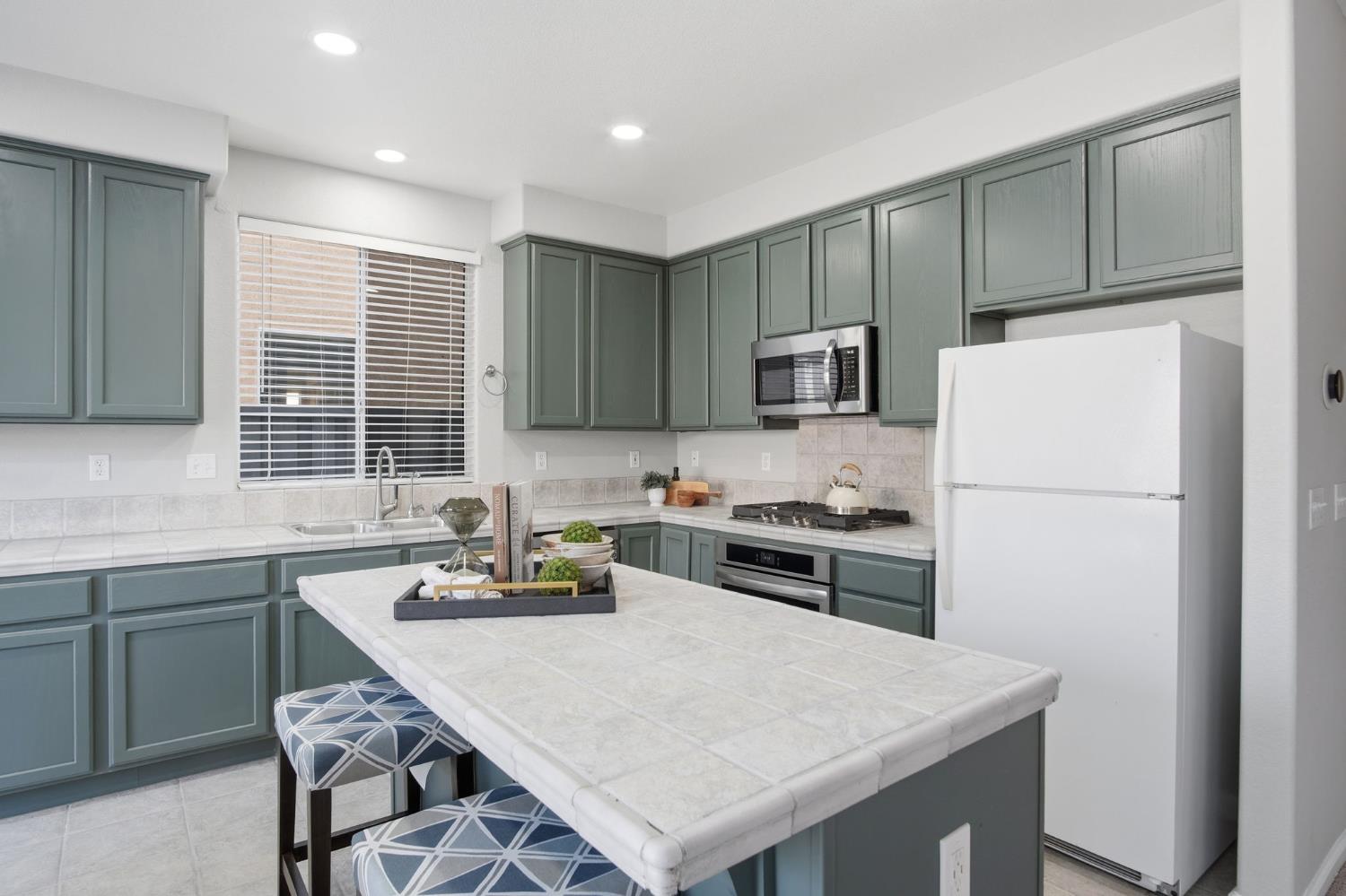 2403 Clemente Lane Tracy, CA 95377 - Photo 9 of 43 a kitchen with refrigerator cabinets and wooden floor