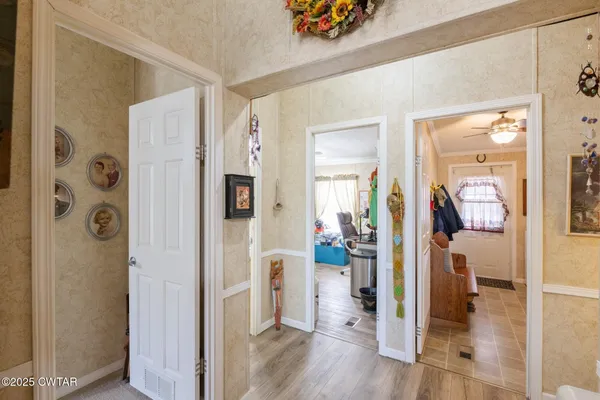 a view of a hallway with bathroom and wooden floor