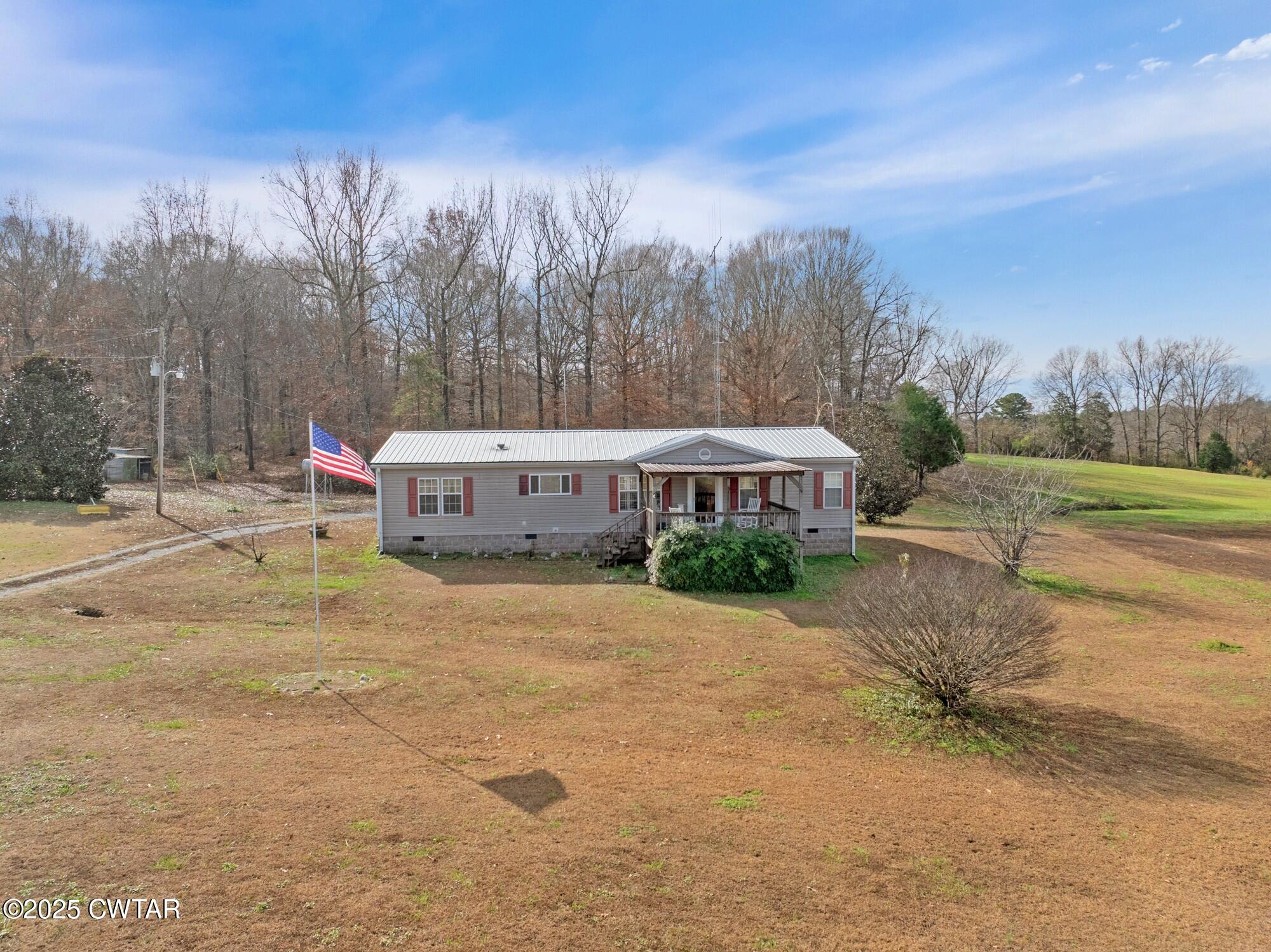 416 Haney School Road Decaturville, TN 38329 - Photo 3 of 35 a front view of a house with a yard and trees