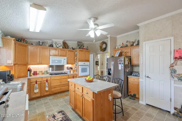 a kitchen that has a lot of cabinets a sink and appliances in it
