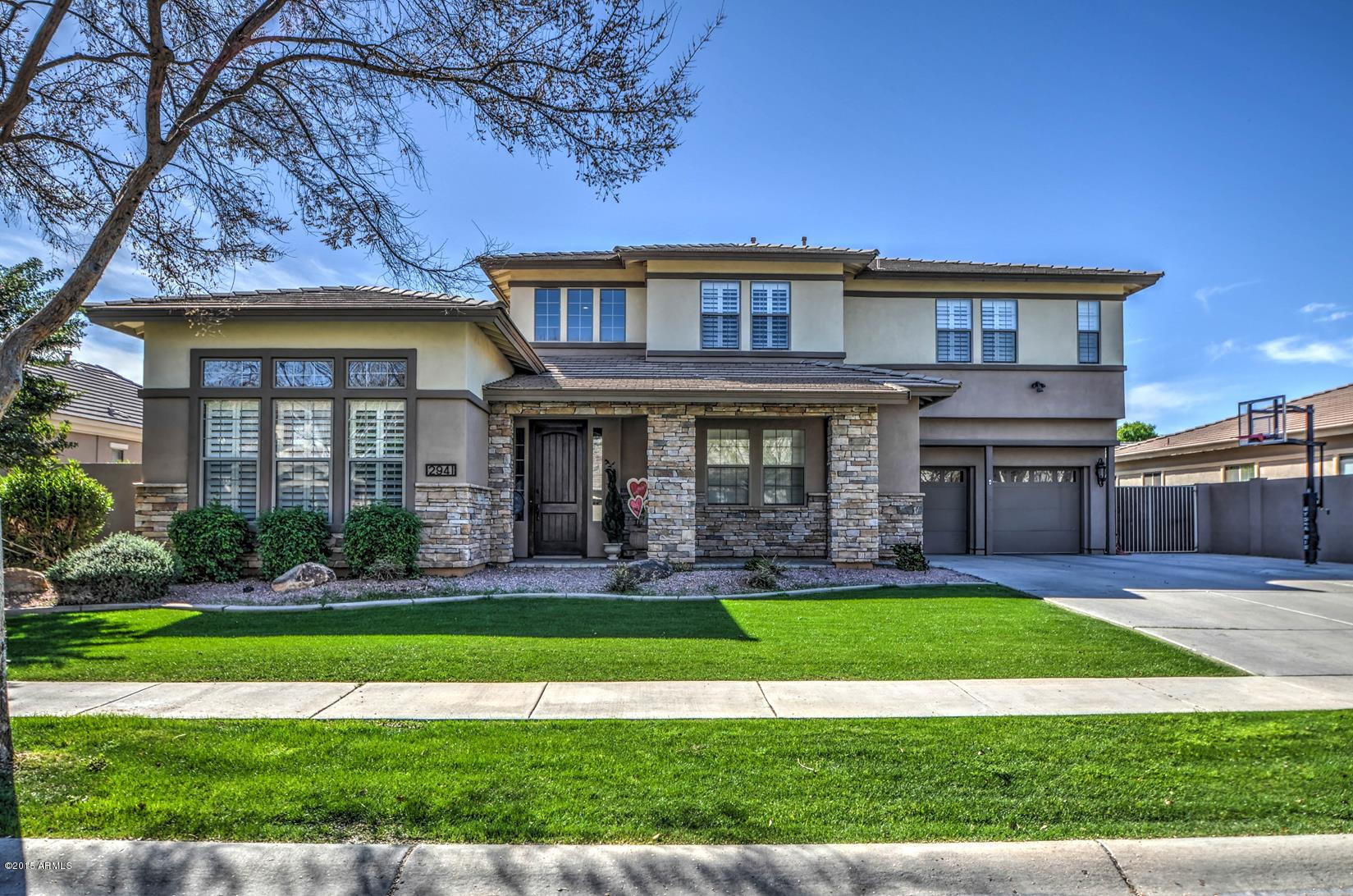 2941 Washington Avenue Gilbert, AZ 85234 - Photo 1 of 57 a view of a big house with a big yard and potted plants and large trees