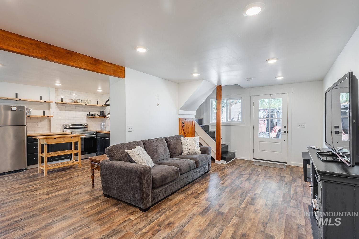 7166 South Cloverdale Road Boise, ID 83709 - Photo 29 of 50 Wood-finish flooring throughout, recessed ceiling lighting, exposed wood ceiling beam, and a white paneled door with glass inserts