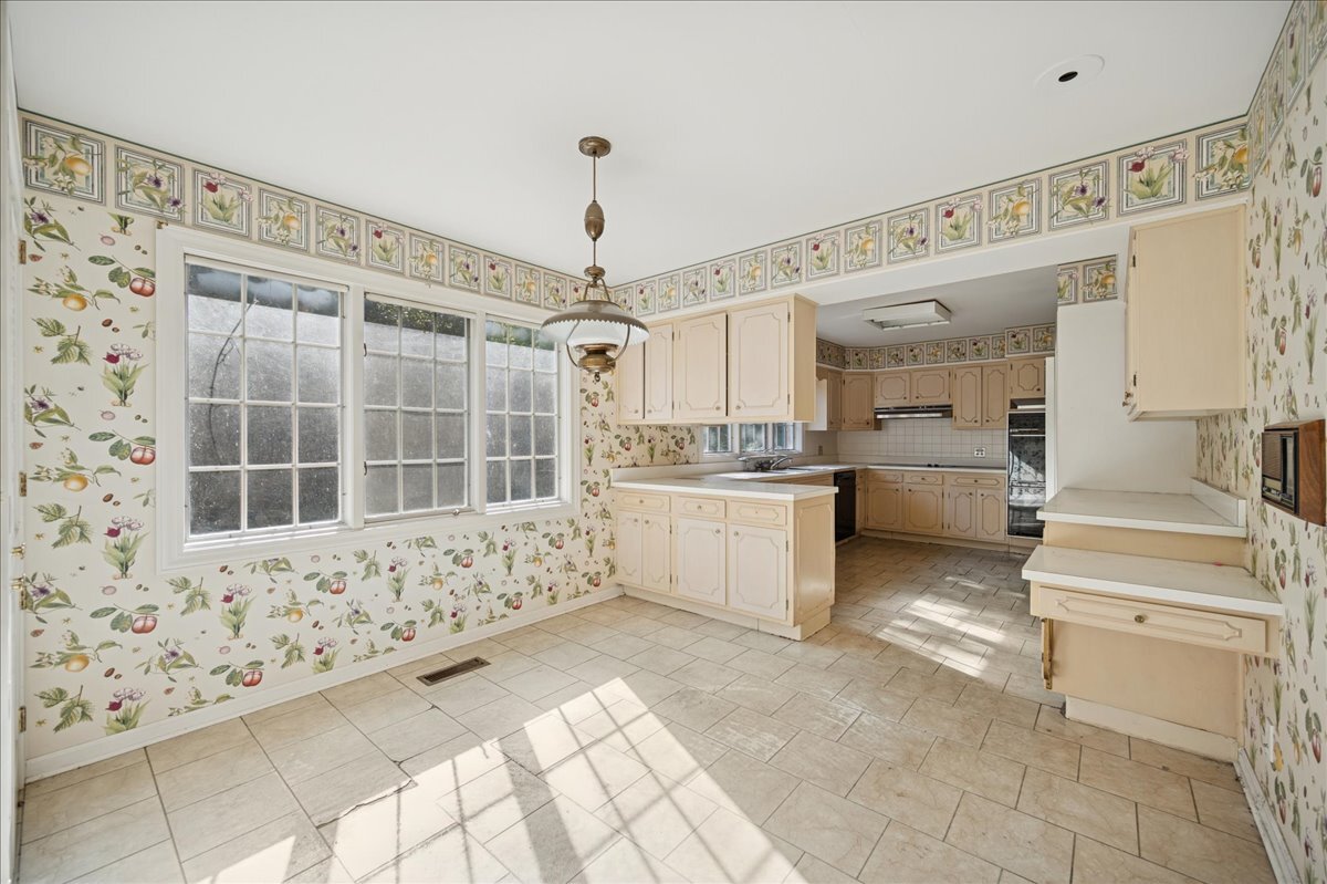 1080 Hillcrest Road Glencoe, IL 60022 - Photo 15 of 33 a large white kitchen with cabinets and a window
