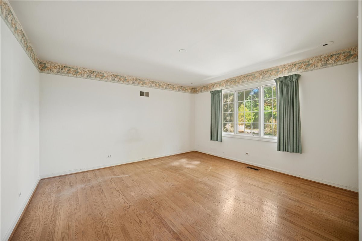 1080 Hillcrest Road Glencoe, IL 60022 - Photo 22 of 33 a view of an empty room with wooden floor and a window