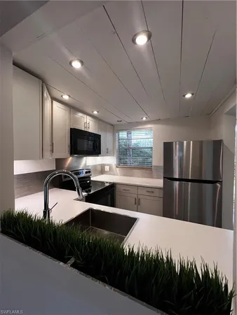 a kitchen with stainless steel appliances a refrigerator sink and cabinets