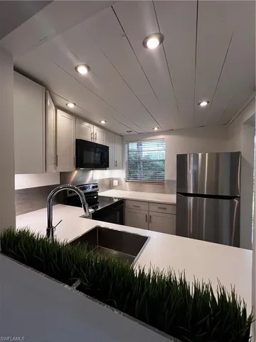 a kitchen with stainless steel appliances a refrigerator sink and cabinets