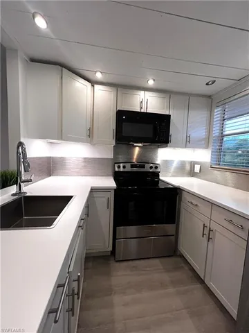 a kitchen with a sink and a stove top oven