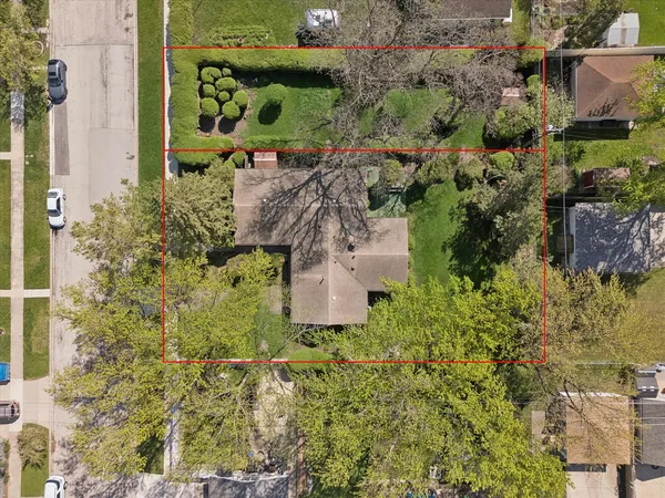 an aerial view of a residential houses with yard