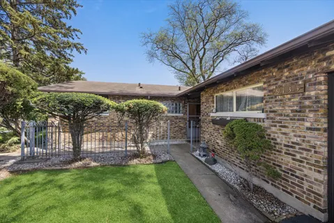 a kitchen with stainless steel appliances kitchen island granite countertop a refrigerator a stove and a wooden floors