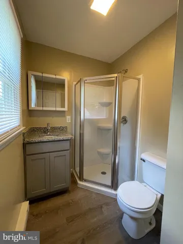 a bathroom with a granite countertop toilet sink and shower